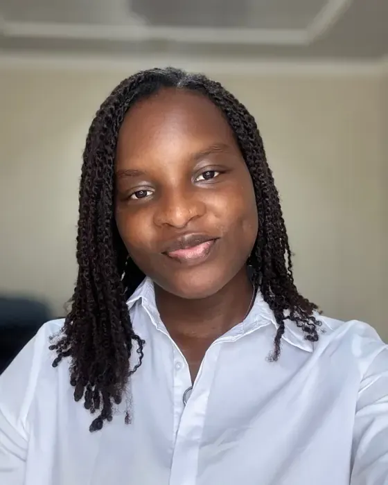 Sidikat in a white shirt, smiling